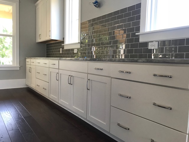 White Shaker kitchen cabinets with a dark gray subway tile backsplash after the remodel
