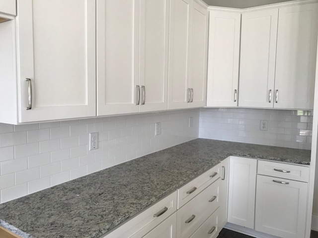 White Shaker kitchen cabinets with gray granite countertops and white subway tile in James Island, SC